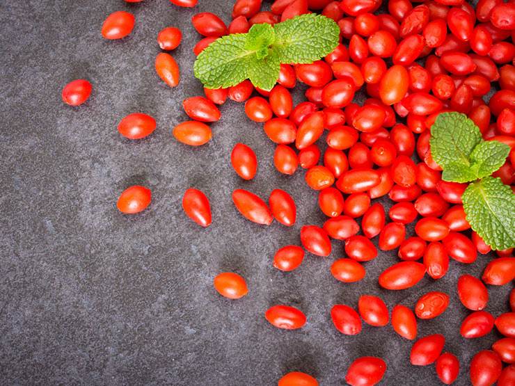 Red ripe goji berries on the floor with leaves