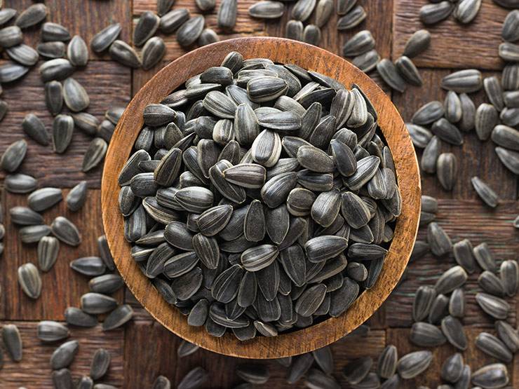 Striped sunflower seeds in a wooden bowl